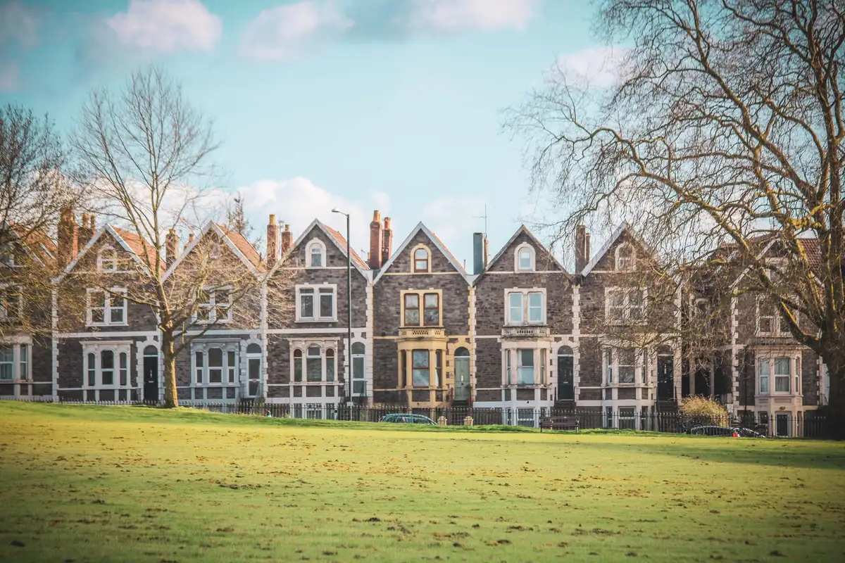 A row of period terraced houses facing a green